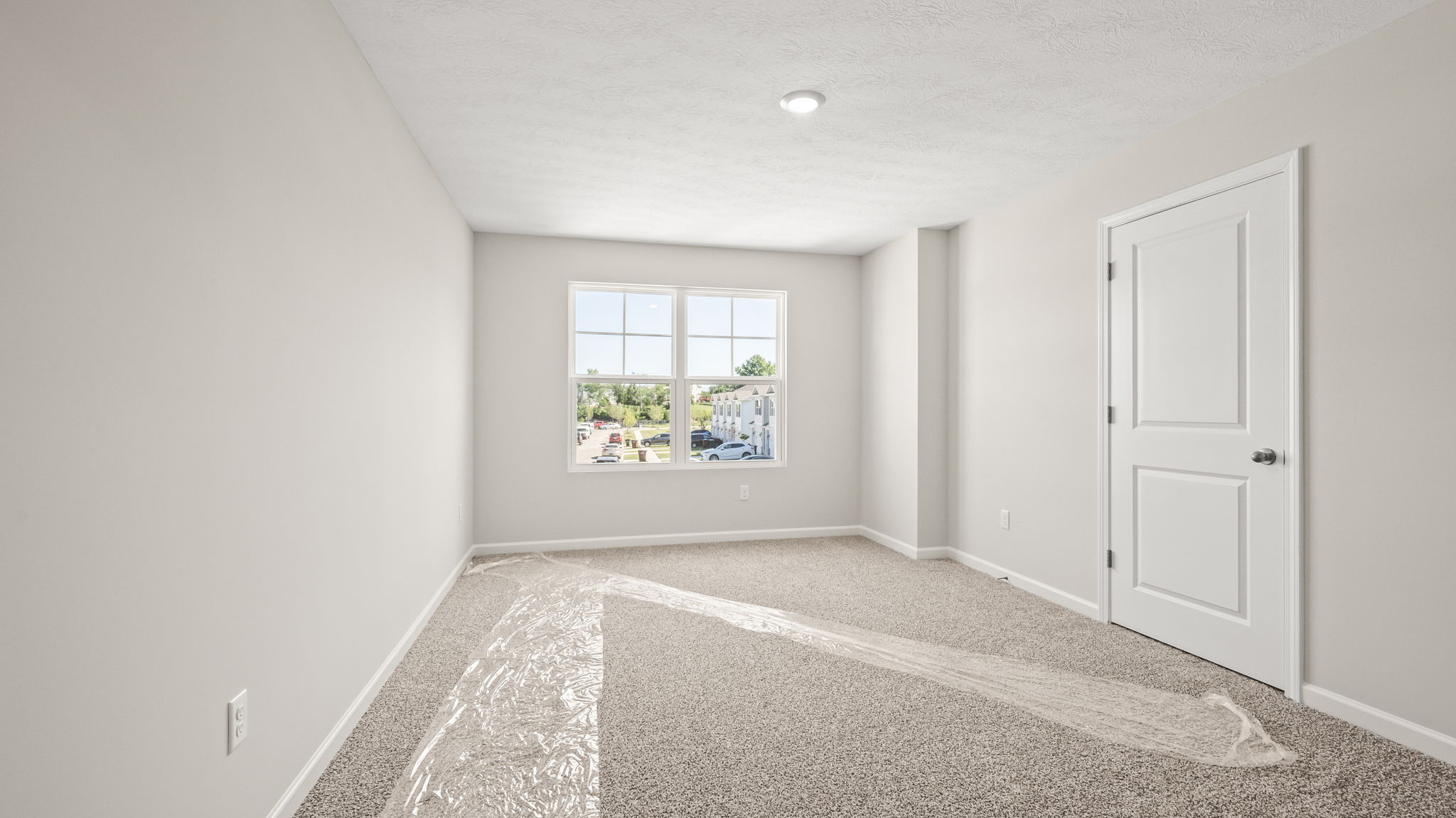 Primary bedroom with window and closet door