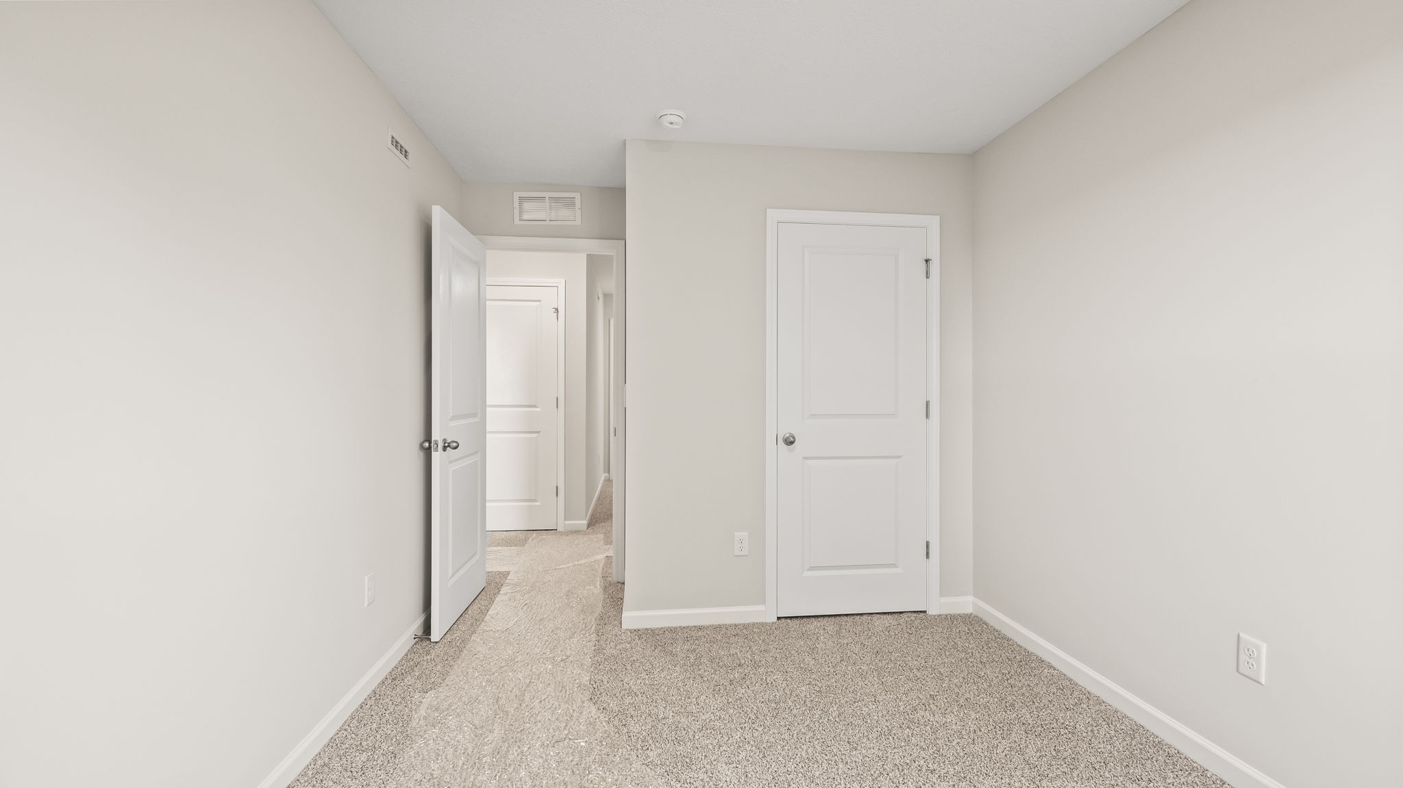 Carpeted bedroom with door to hallway