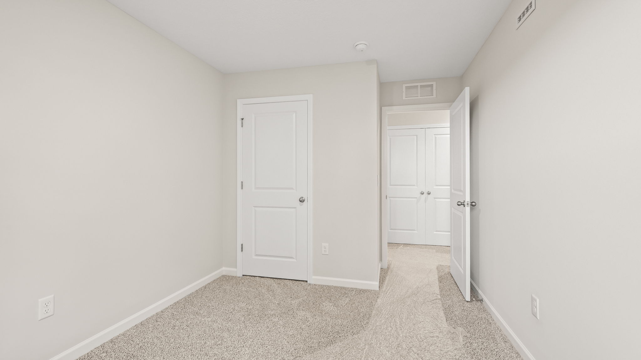 Carpeted bedroom with door to hallway