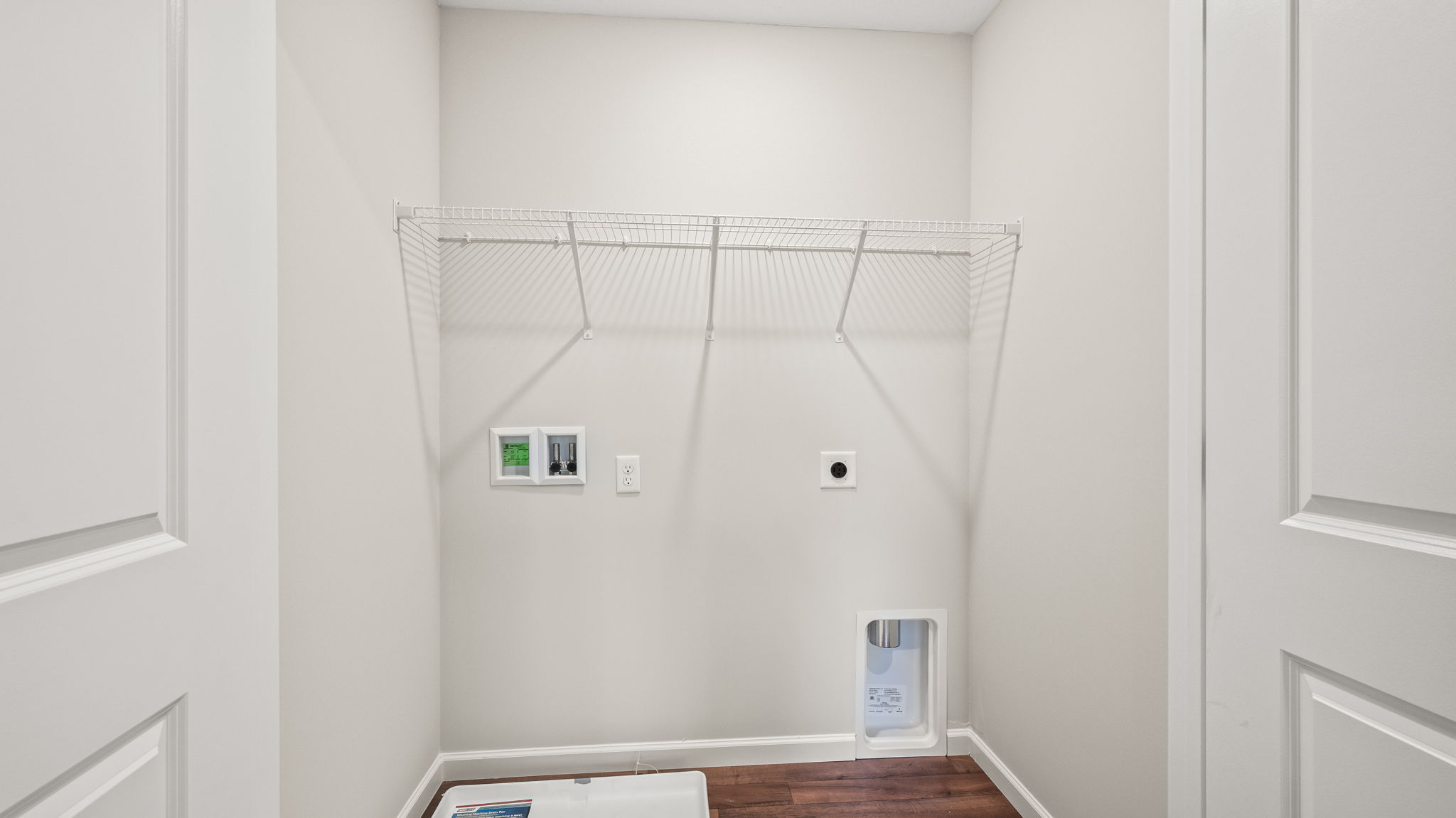 Laundry area with washer/dryer inlets and wire rack shelving