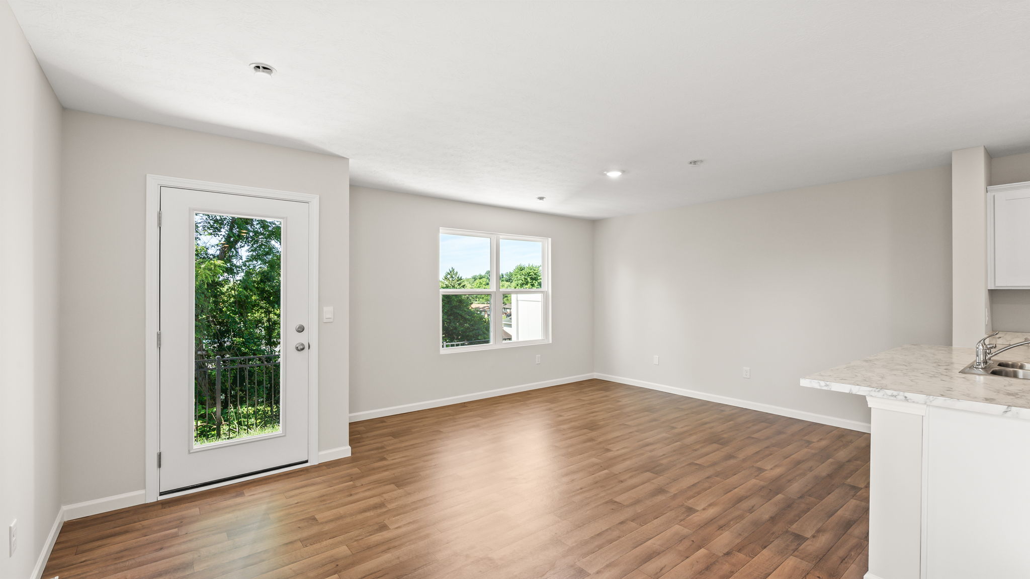 Wide image of living room with door to backyard