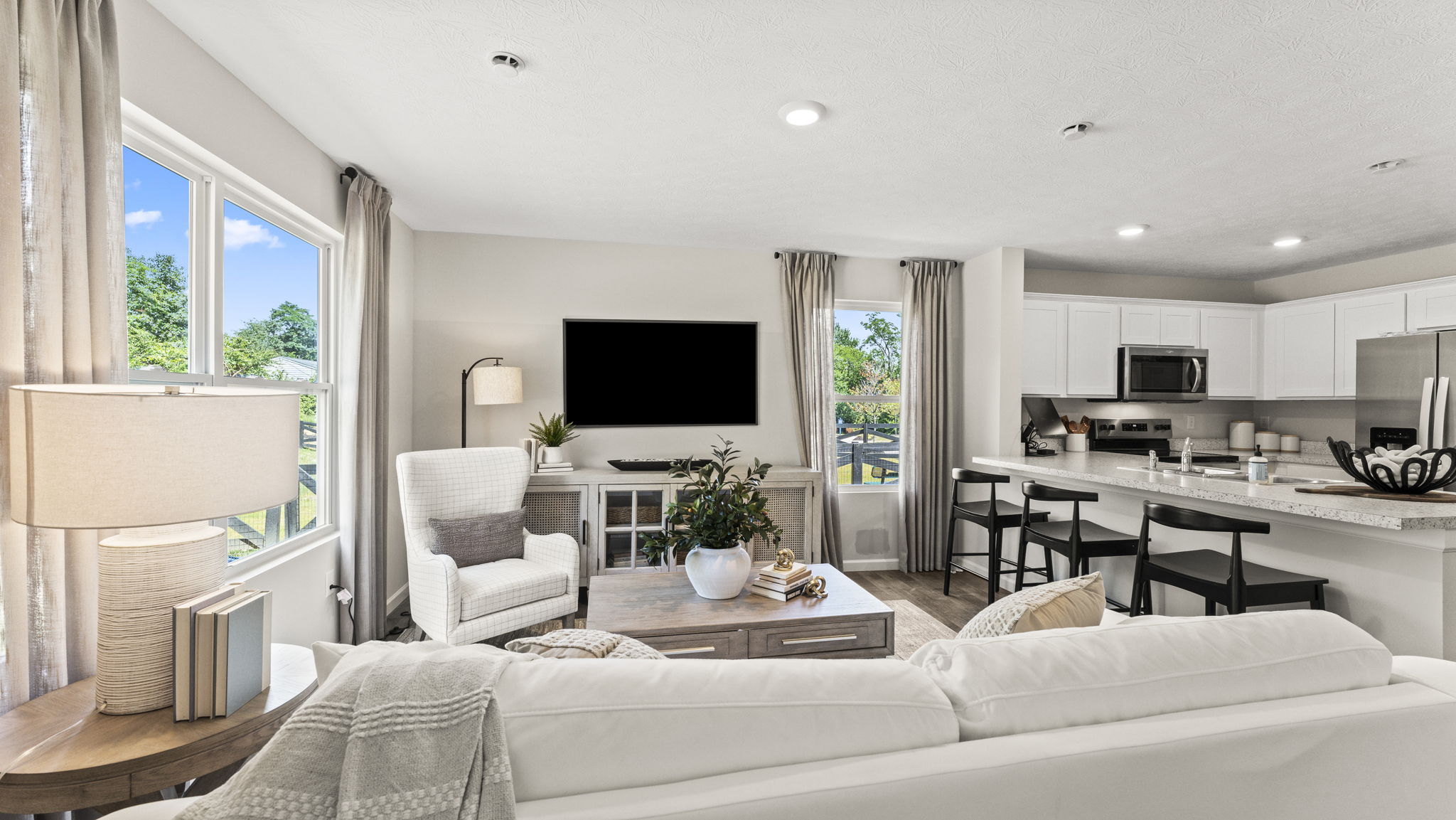 Living room with comfy white couch, modern accents, and artwork.
