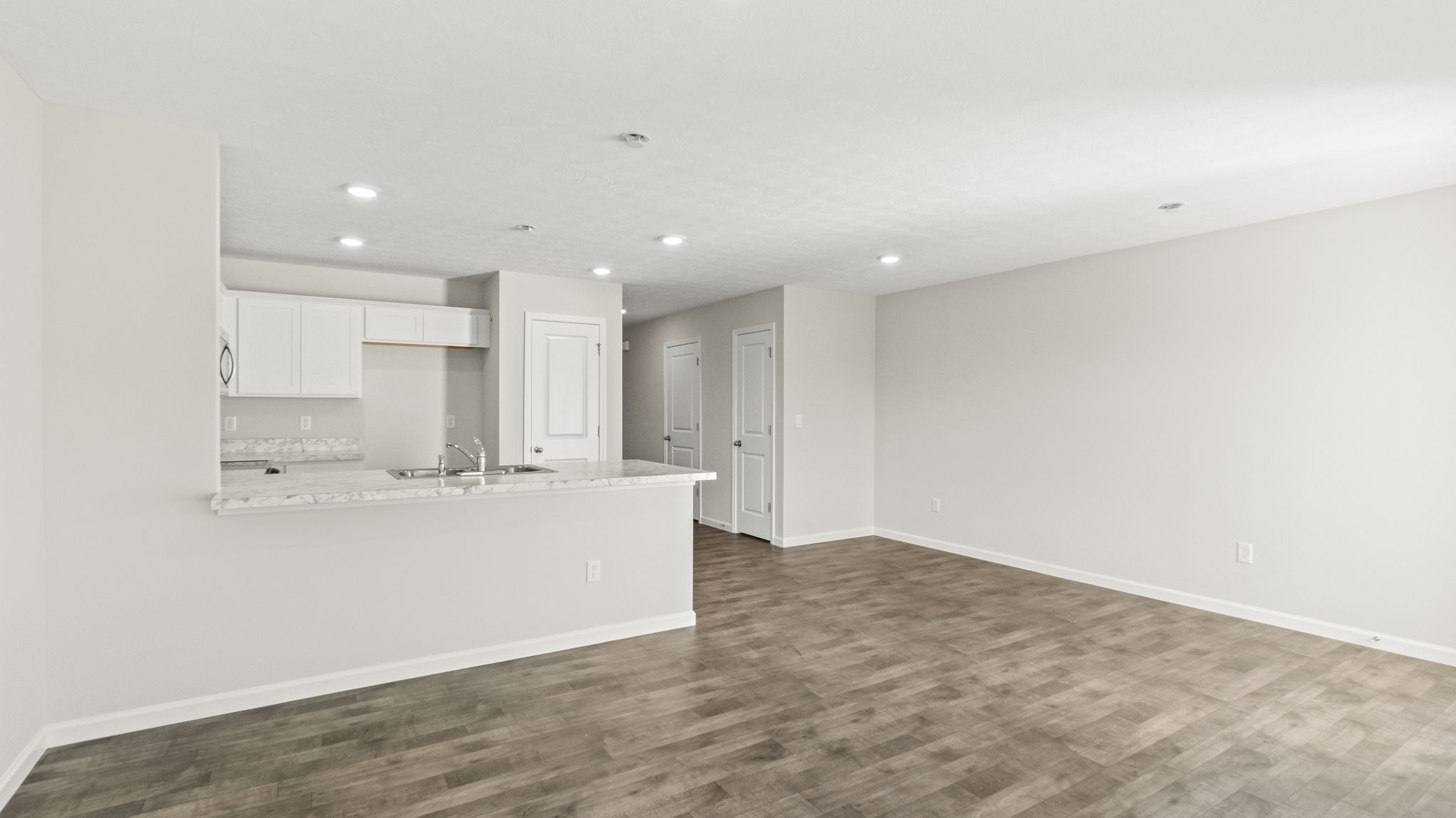 View of the great room from the corner looking at kitchen and hallway