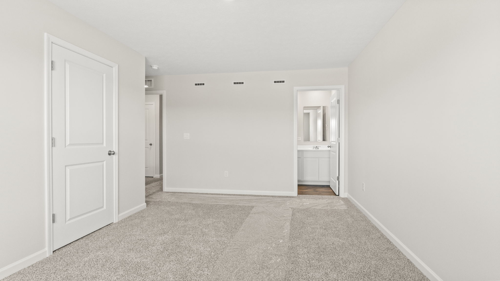 Primary bedroom with door to walk-in closet and primary bathroom