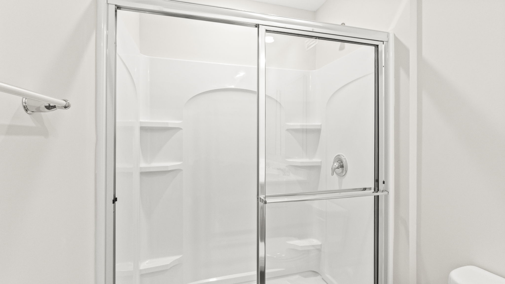 Closeup of wlak-in shower with wire shelving.