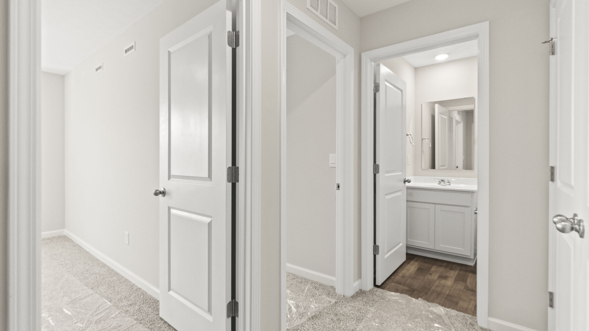 Upstairs hallway looking into bathroom and two bedrooms.