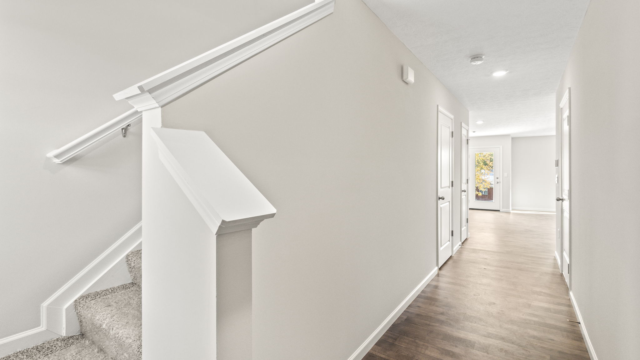 Downstairs foyer with view of the stairs going up and great room.