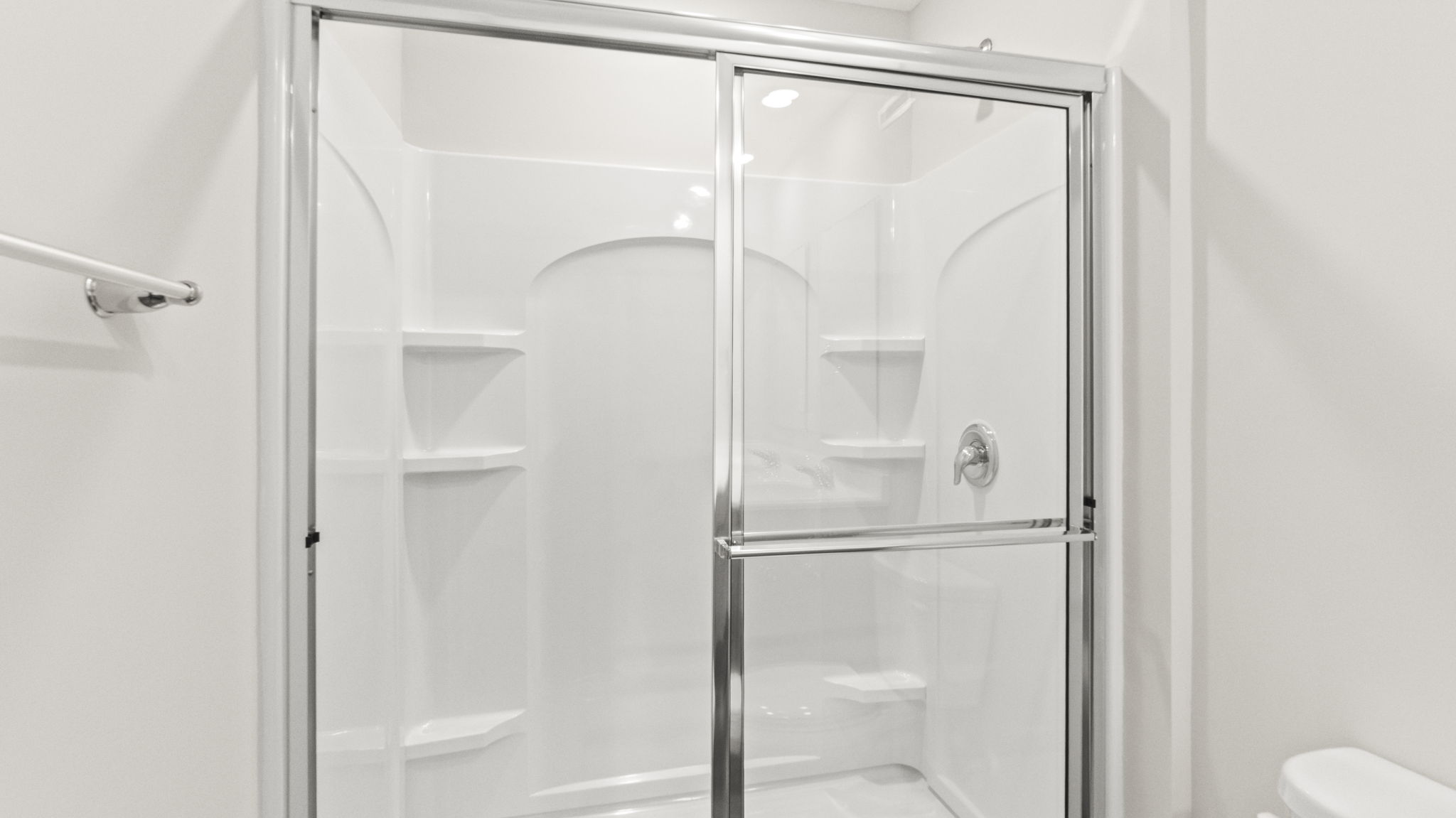 Closeup of walk-in shower with wire shelving.