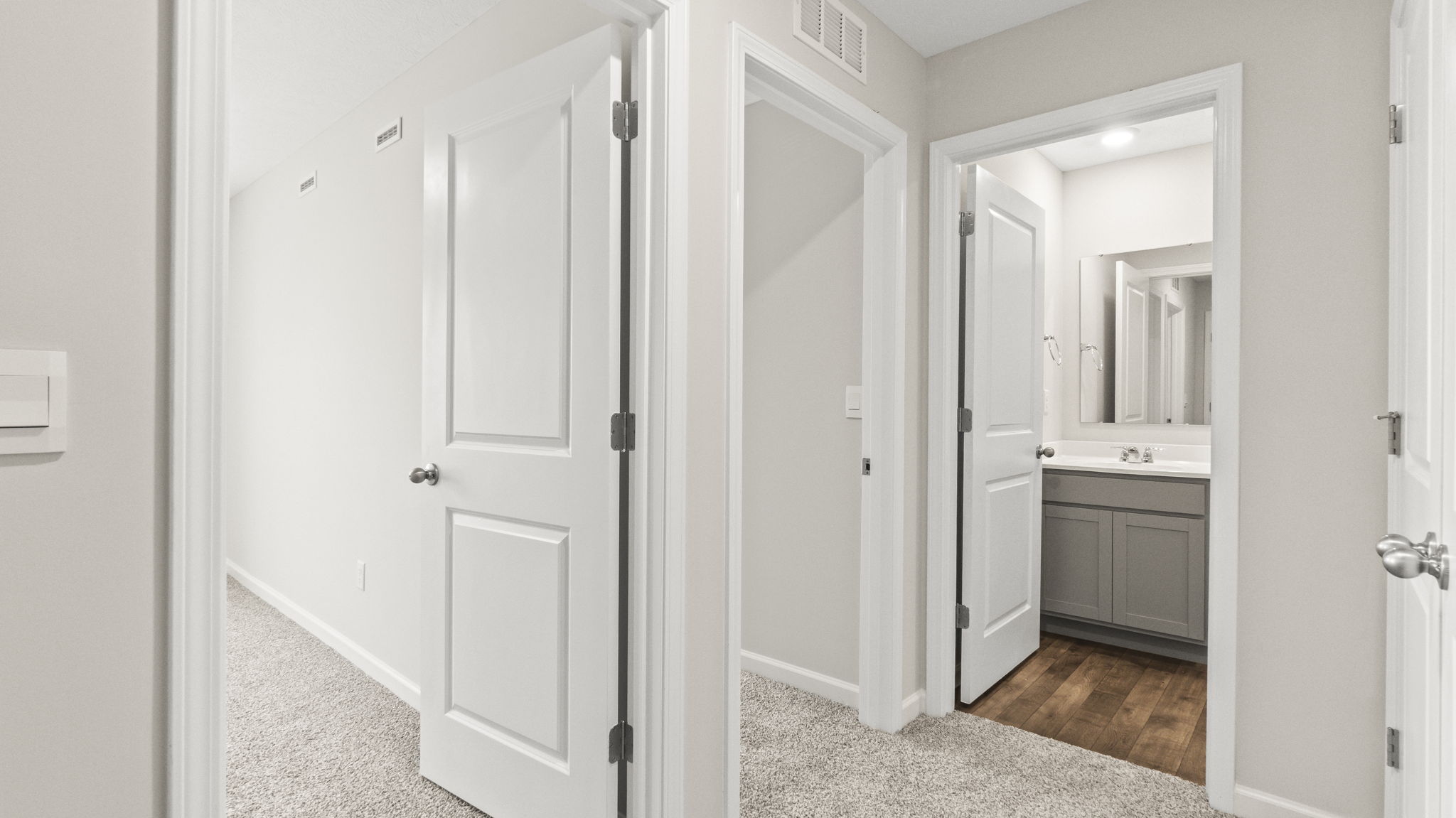 Upstairs hallway looking into bathroom and two bedrooms.