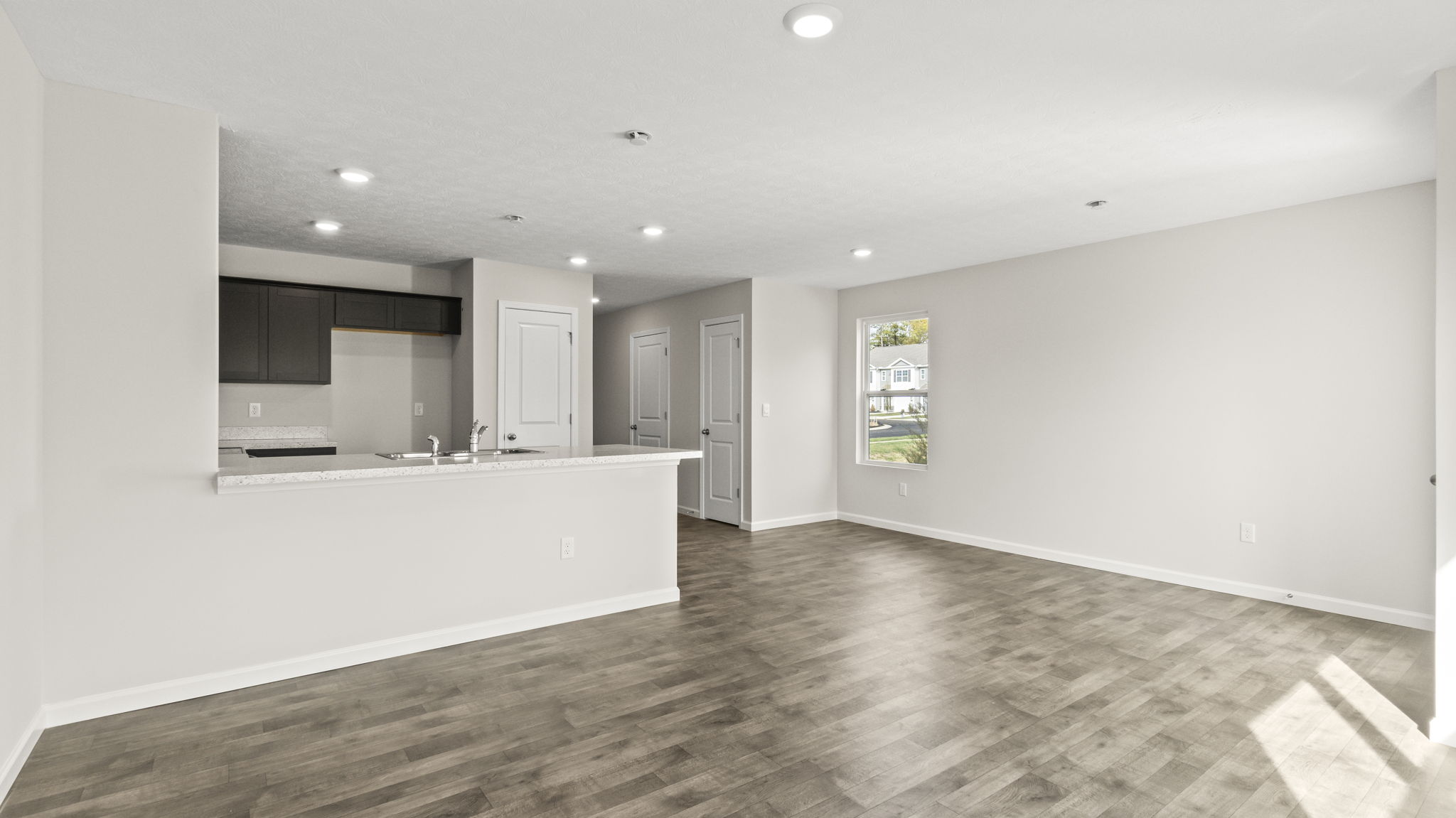 View of the great room from the corner looking at kitchen and hallway