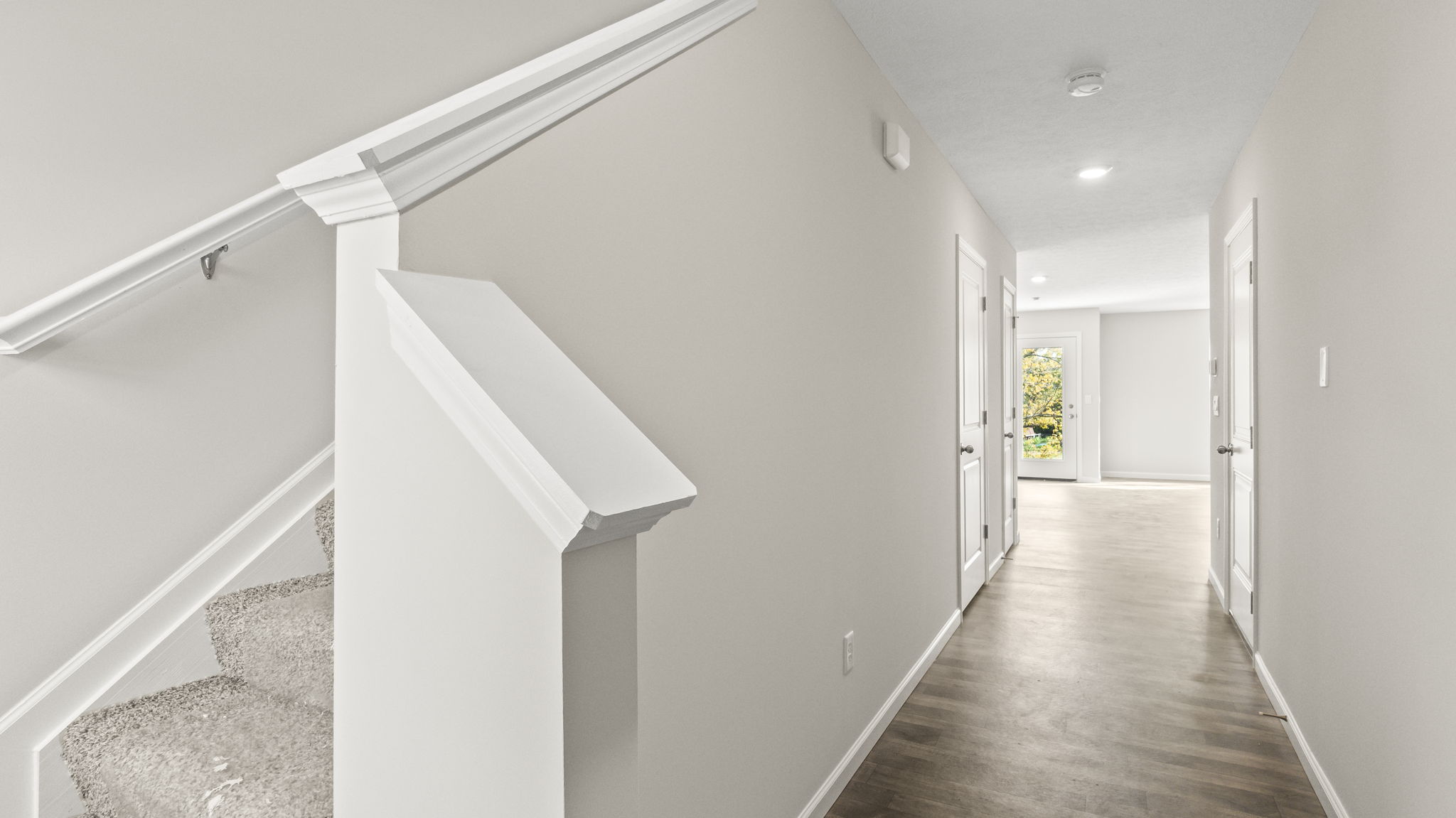 Downstairs foyer with view of the stairs going up and great room.