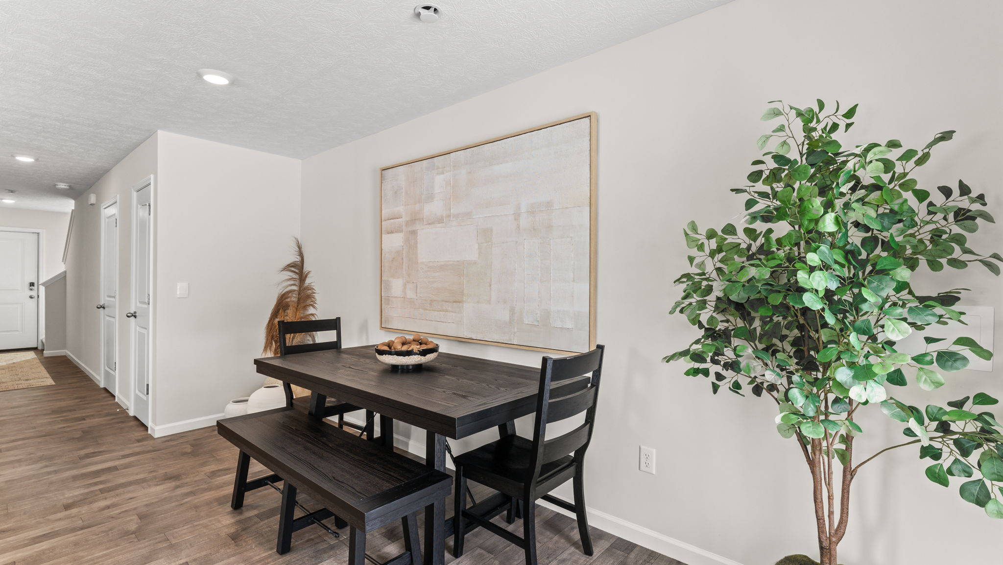 Picnic bench style dining table next to abstract art and plant for decoration