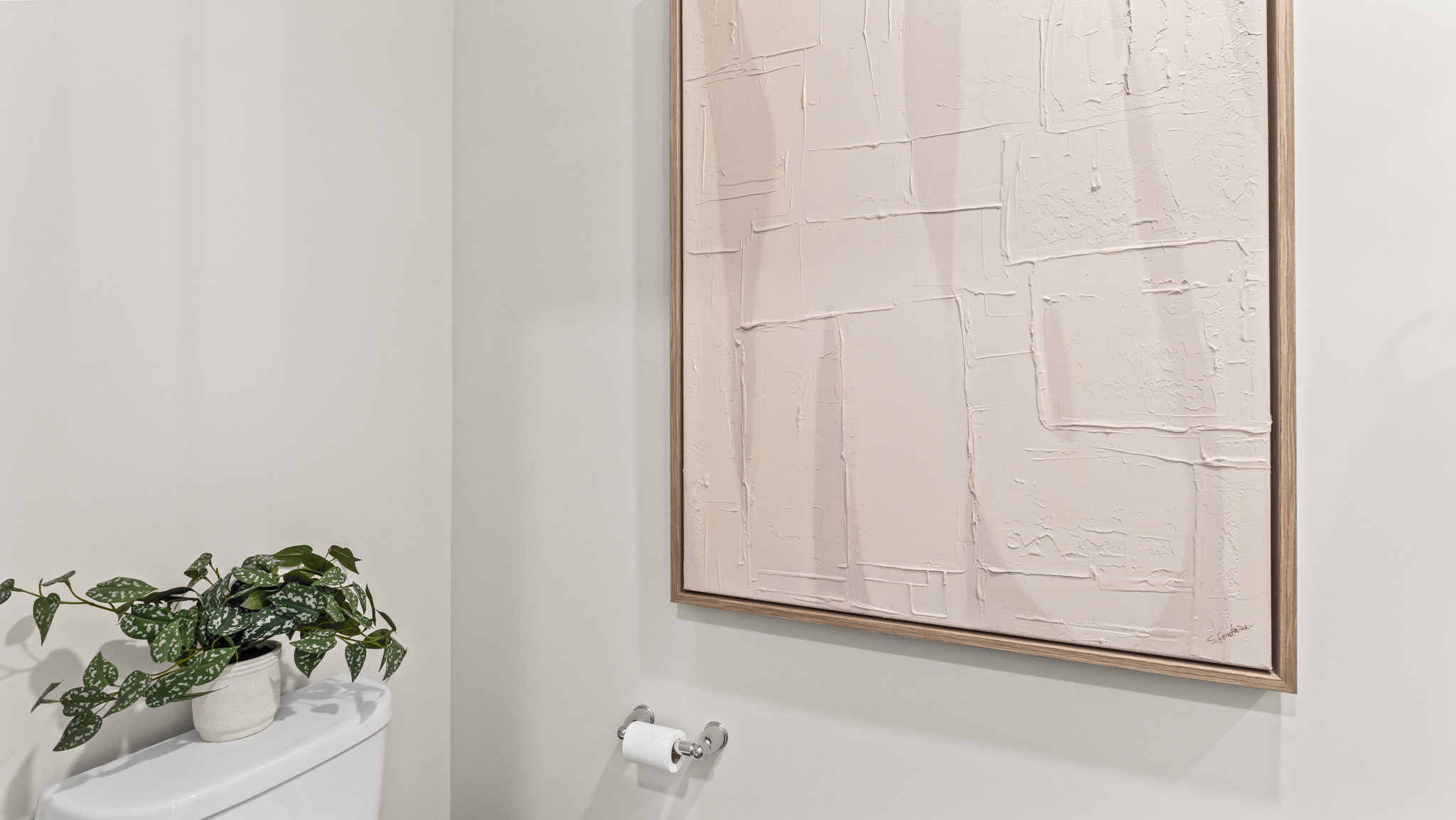 Closeup of toilet and painting in powder room