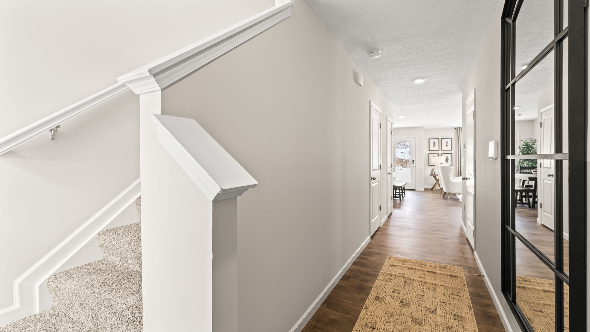 Front of the home foyer with stairs to second level on the left and hallway on the right