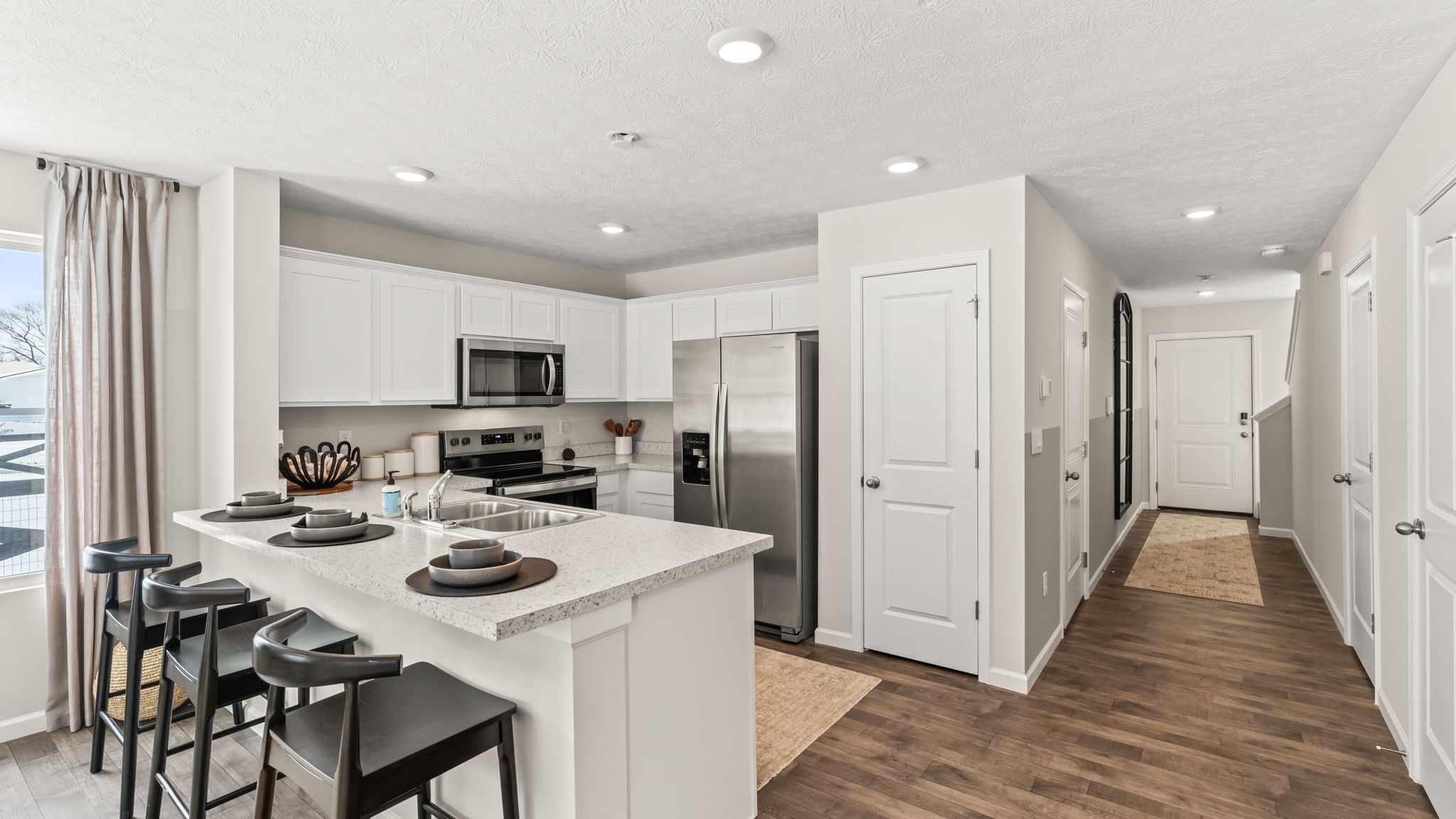 Wide image of townhome kitchen with view of the hallway that goes to the second level