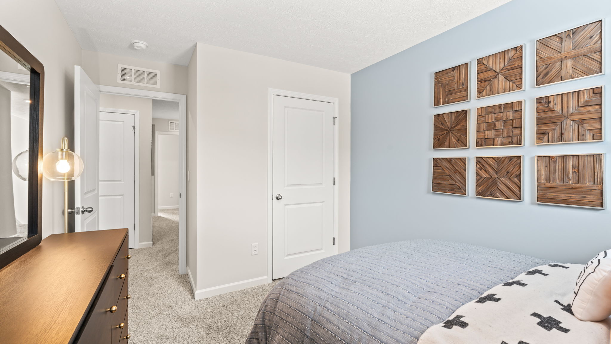 Blue and white painted bedroom with full-sized bed and door to closet