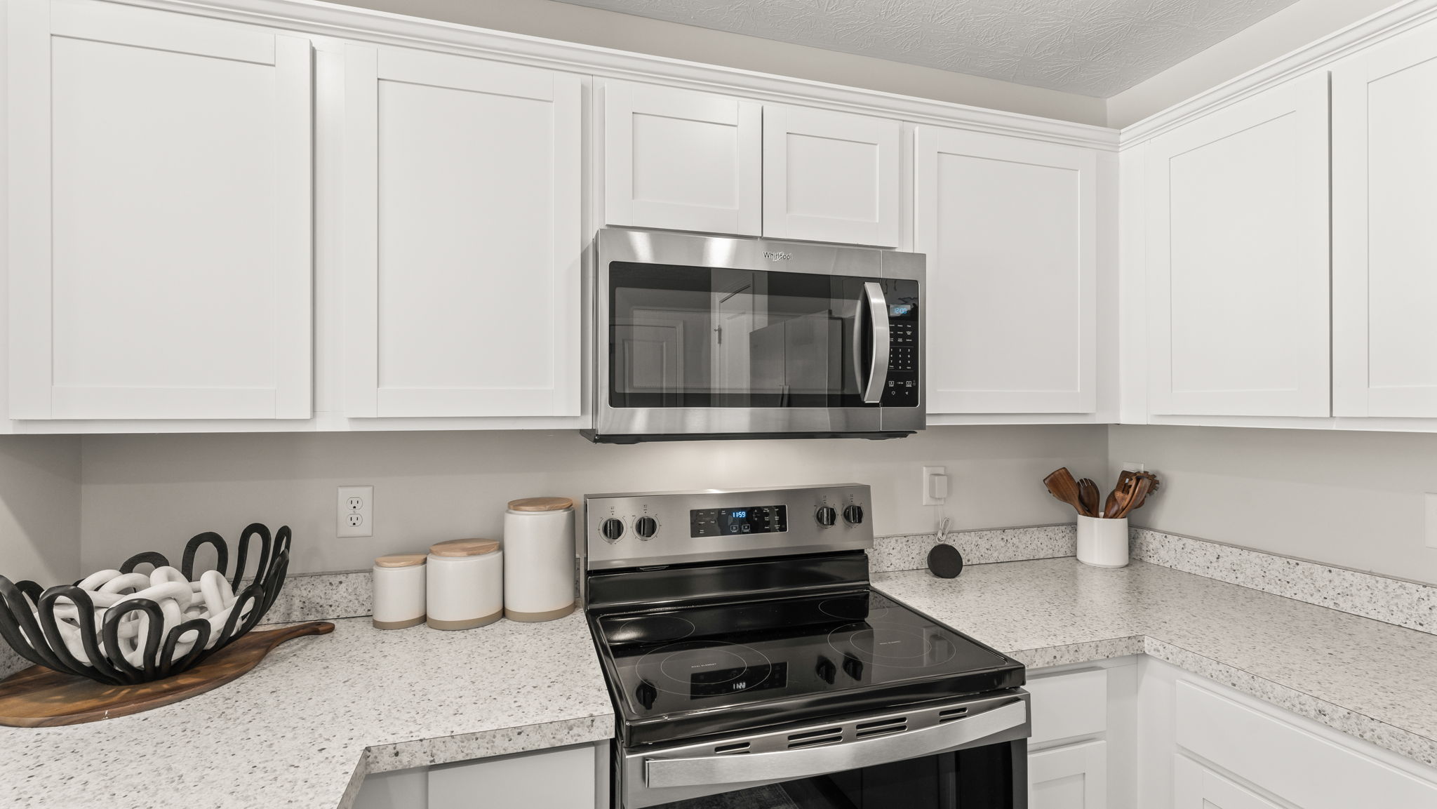 Closeup of kitchen oven range between white cabinets and laminate countertops