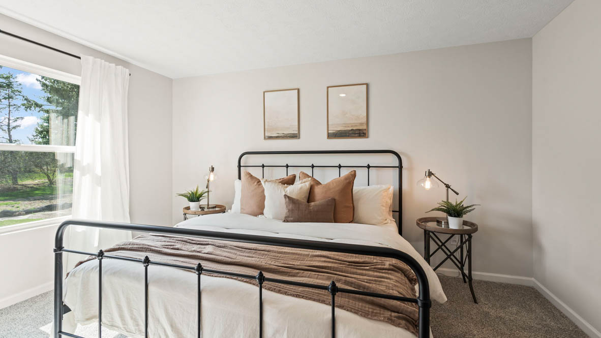 Primary Bedroom with large king size bed large windows and matching bedside tables.
