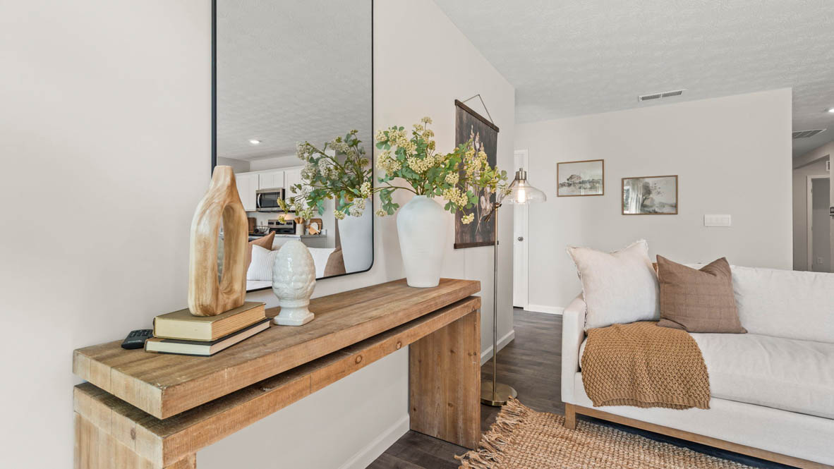 side view of living room with mirror and decorated table.