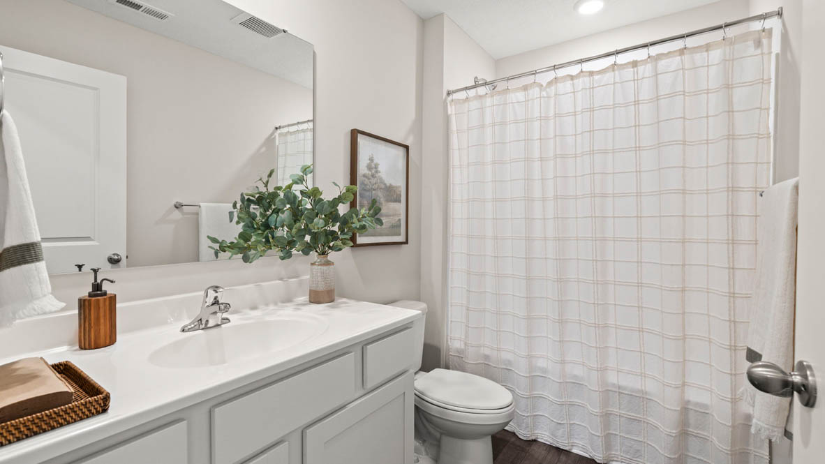Shared bathroom with sink, toilet, and shower.