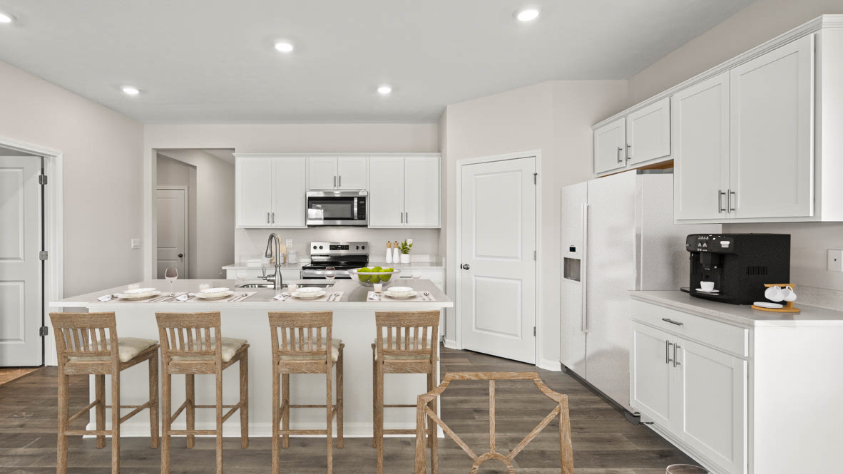 Full view of Open Concept kitchen with wooden chairs stainless steel appliances and espresso machine.