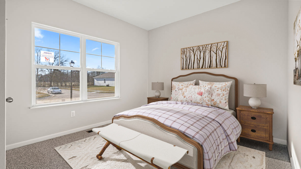 front bedroom with large bed dual bedside tables and decorative art.