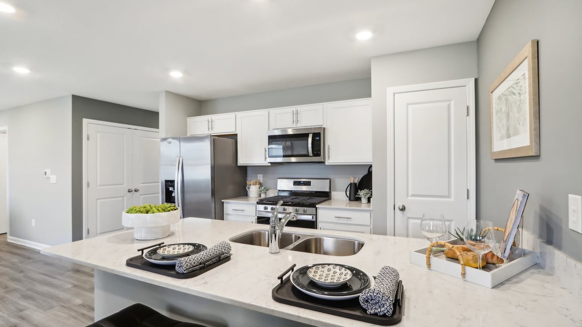 Kitchen with penisula with stainless steel appliances and white cabinets.