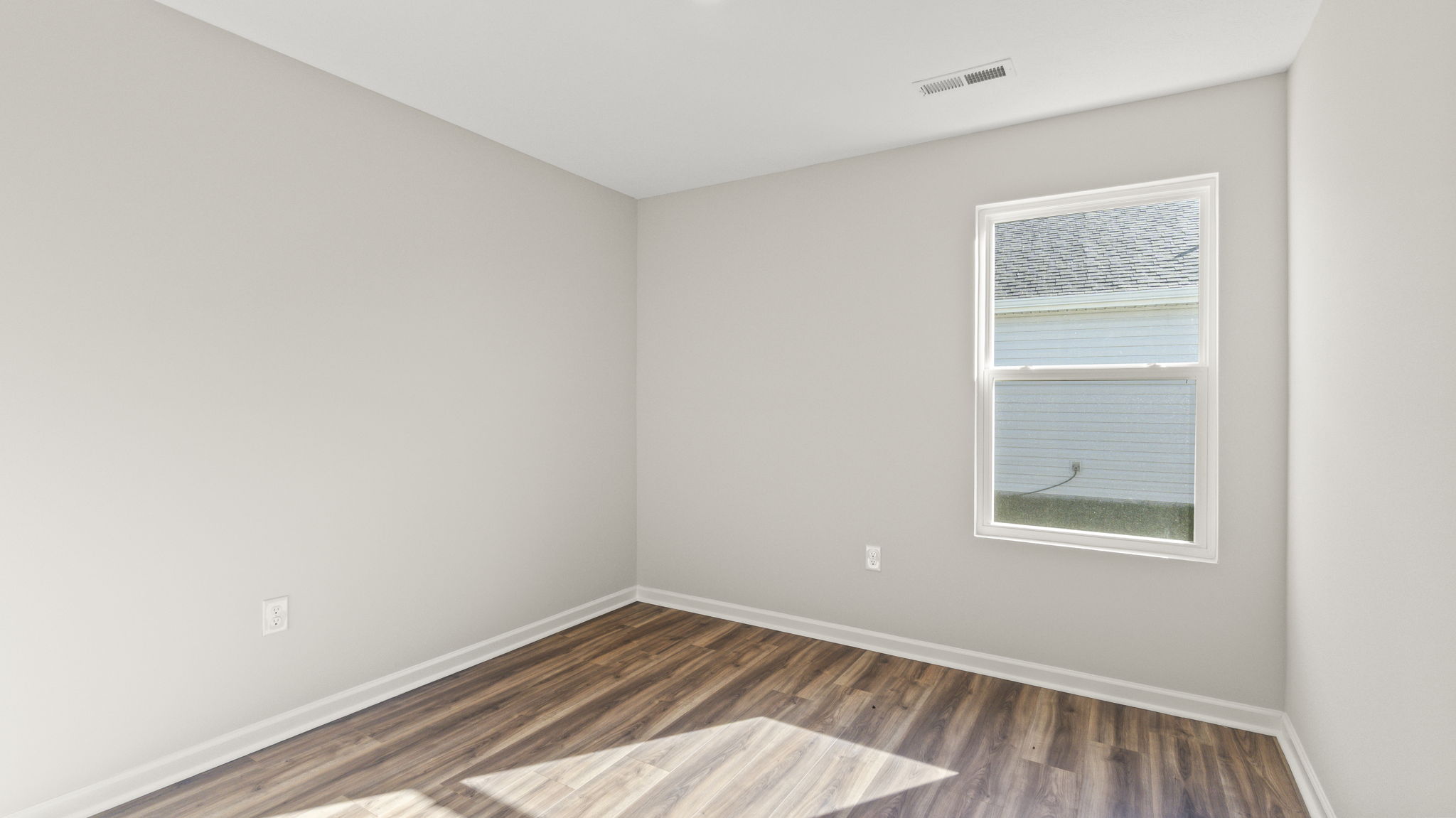 Bedroom 2 witb window, outlets, and wood flooring