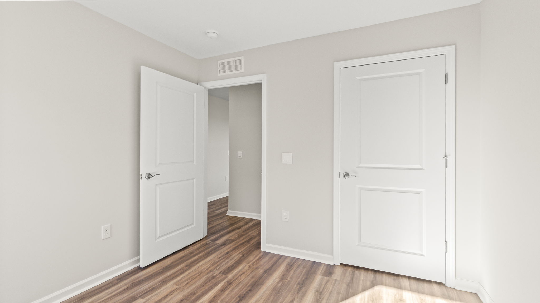 Bedroom 2 with wood flooring and closet looking into the hallway