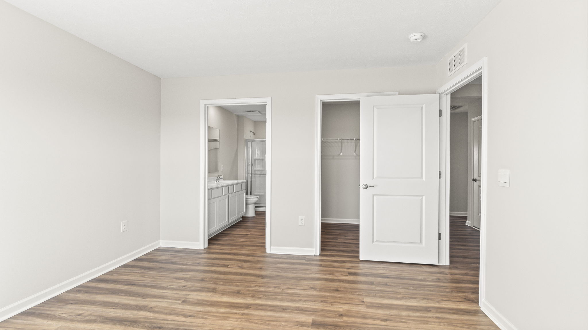 Primary bedroom looking into primary bathroom and walk-in closet