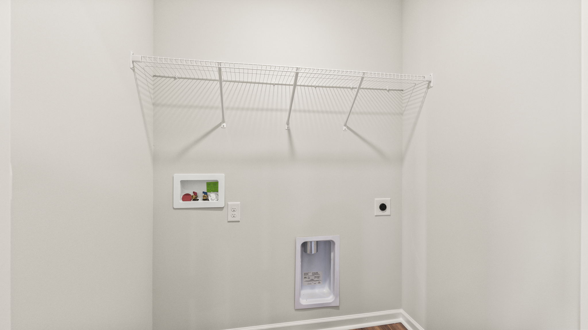 Laundry room with washer inlets and wire shelving