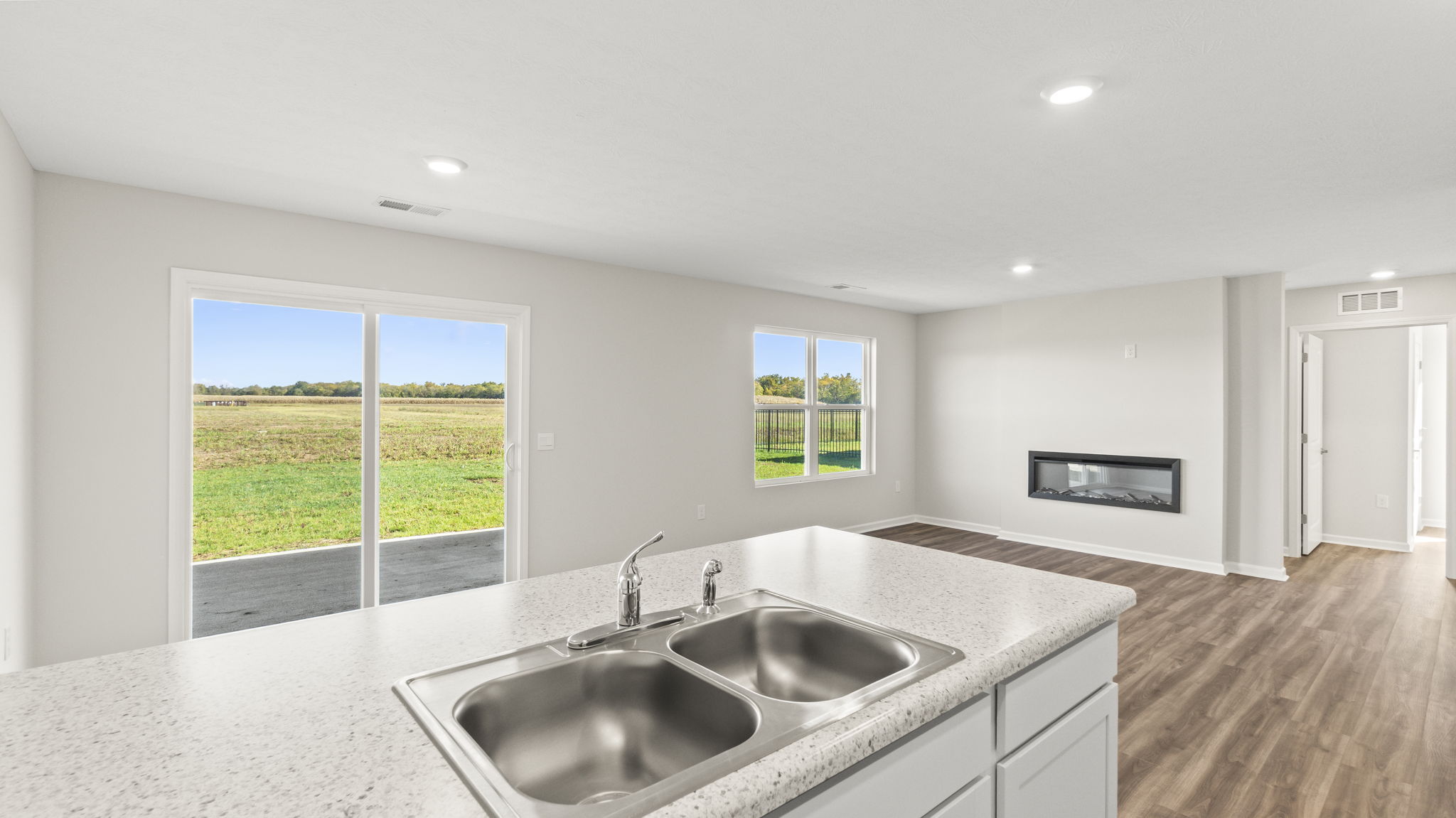 View of the great room and electric fireplace from the kitchen sink