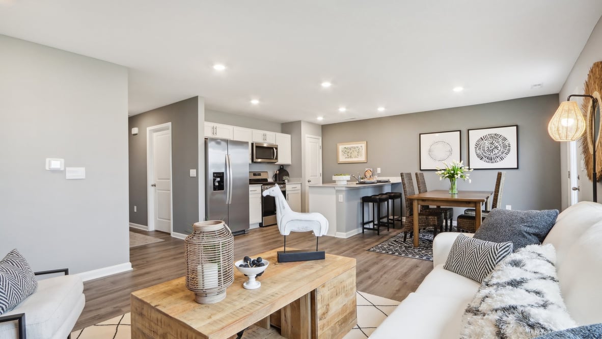 Great room decorated with modern art and dining room and kitchen.