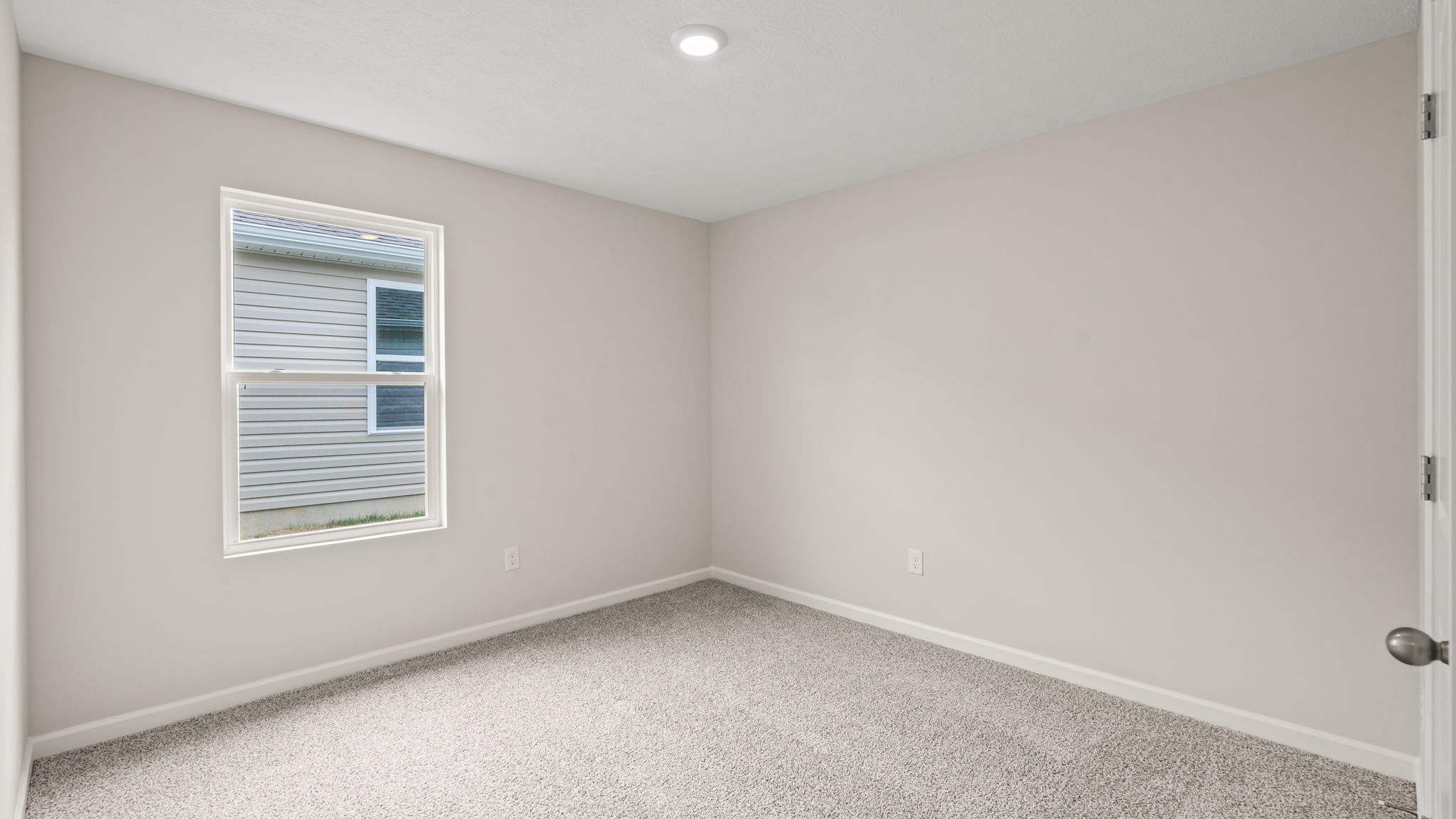Bedroom with window and carpeted floors.