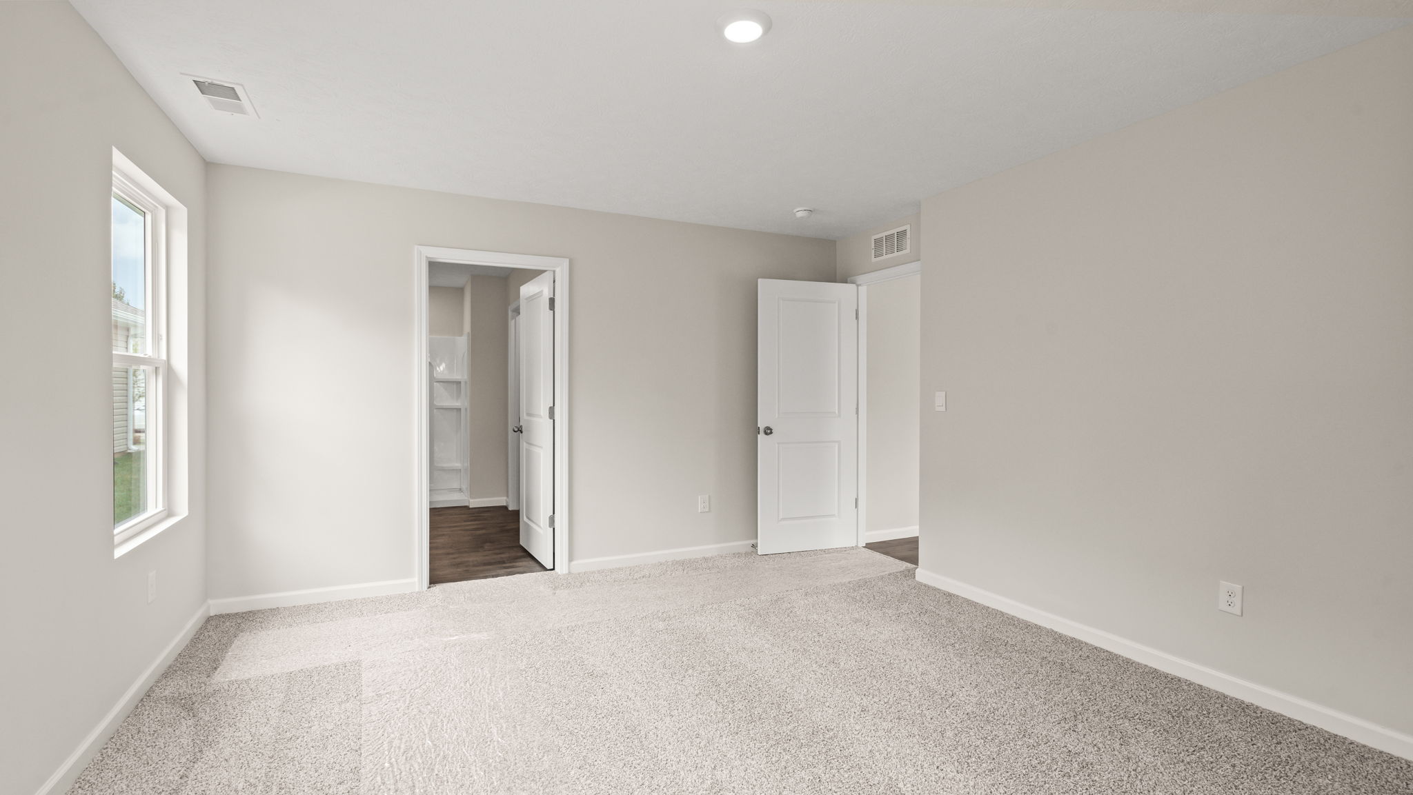 Bedroom with carpeted floors and ensuite bathroom.