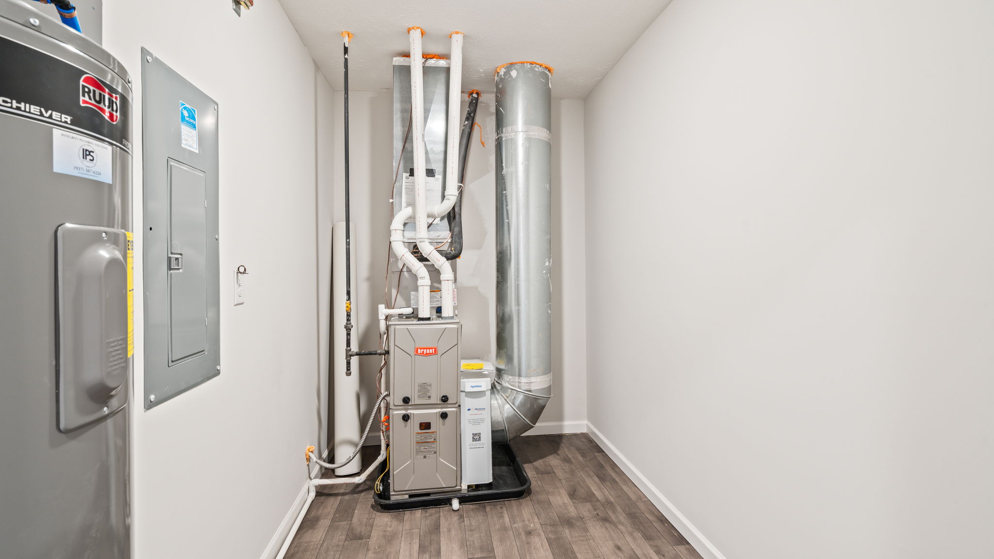 Storage room with mechanical panel and water heater.