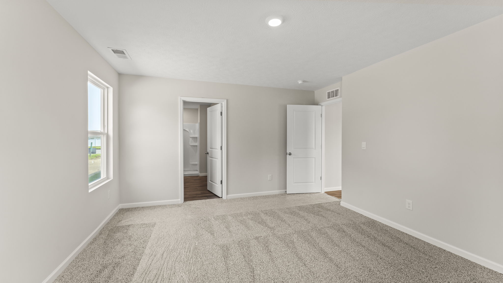 Bedroom with carpeted floors and an ensuite bathroom.