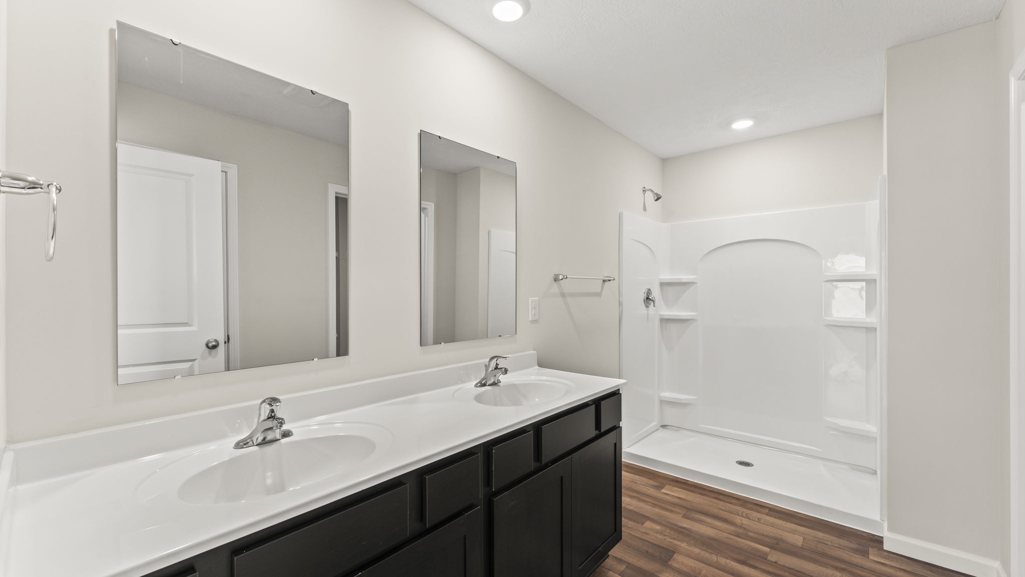 Bathroom with a dual vanity sink and a walk in shower.