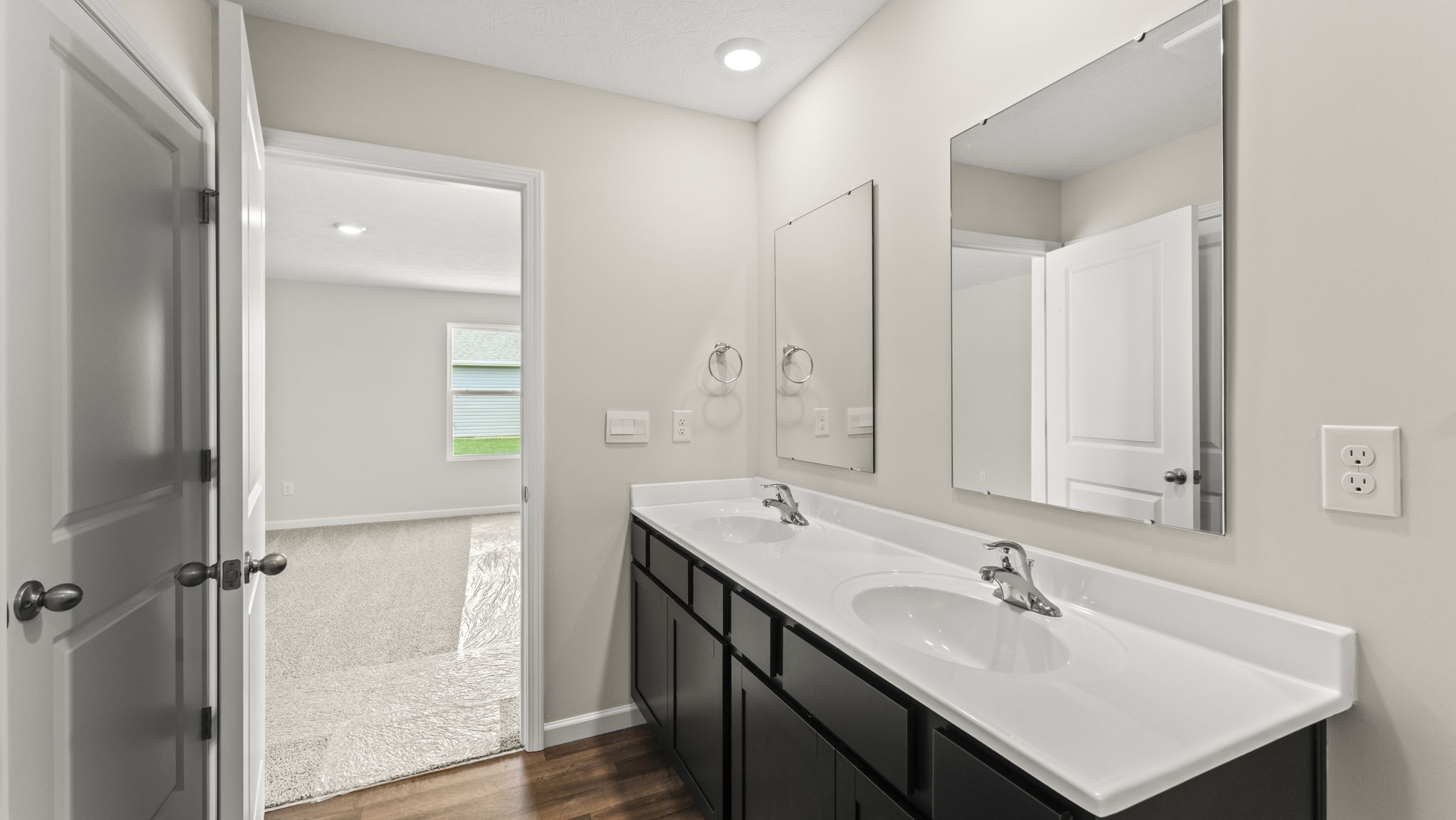 Bathroom with white countertops and dark cabinets.