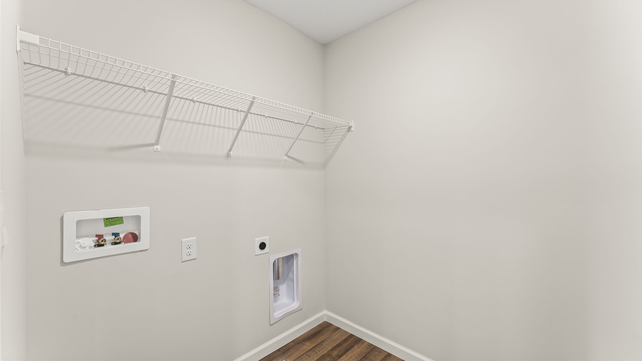 Laundry room with brown flooring.