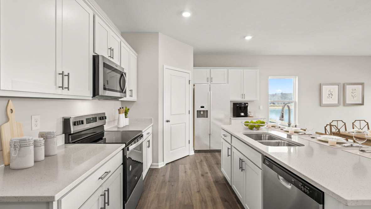 shotgun view of kitchen with stainless steel appliances and white cabinet.