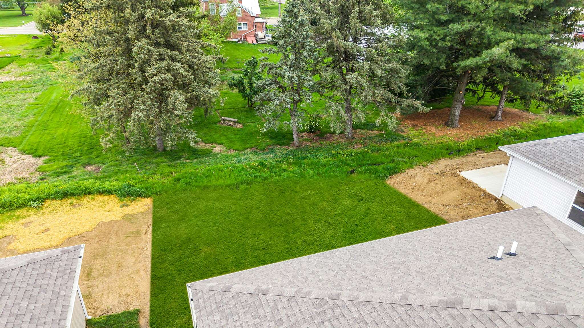 Aerial viw of backyard with large grassy area.