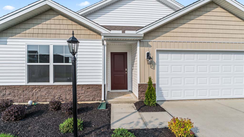 Front exterior of home with partial brick siding.