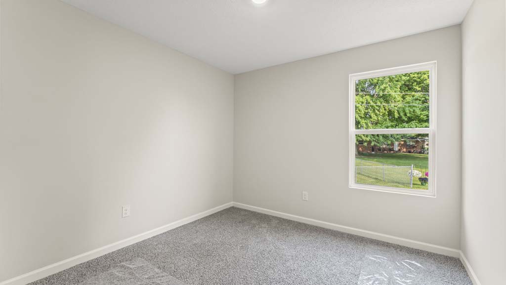 Bedroom with carpeted floors and a window.