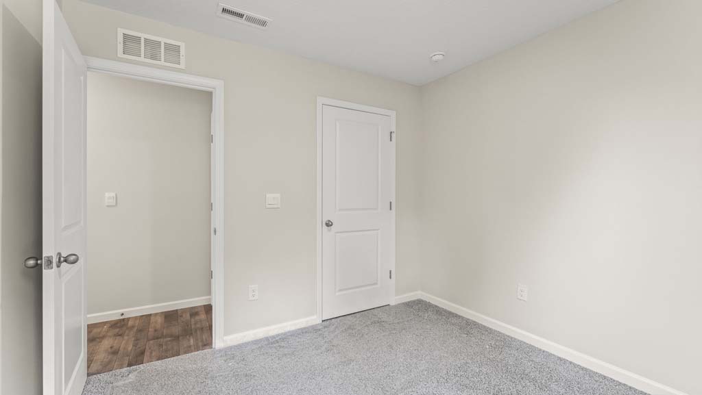 Bedroom with a closet and carpeted floors.