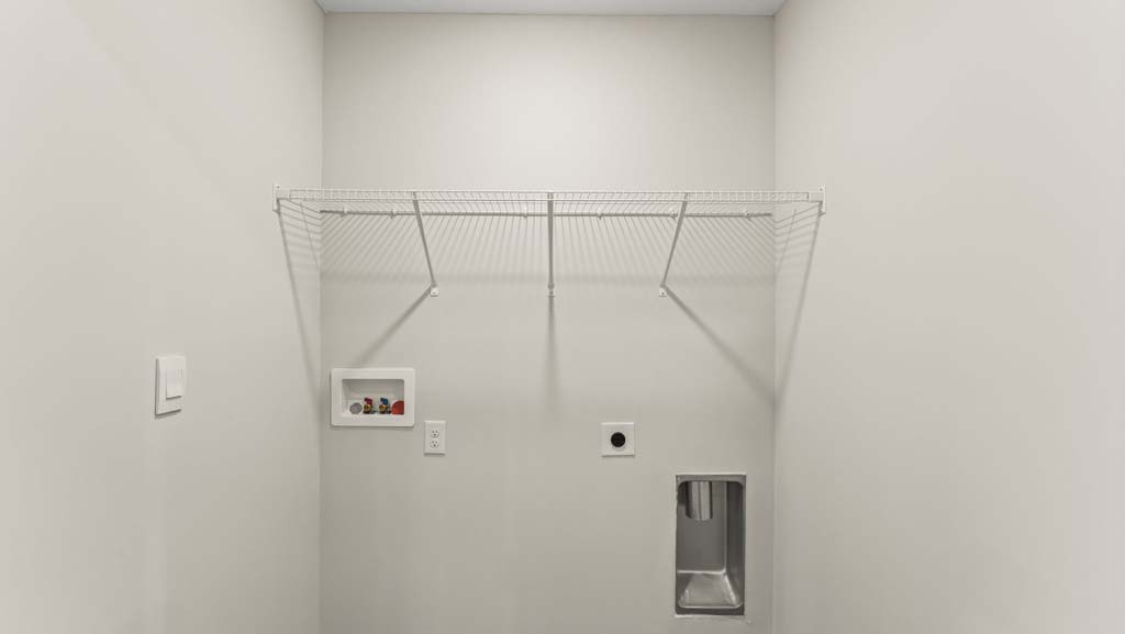 Laundry room with brown flooring.