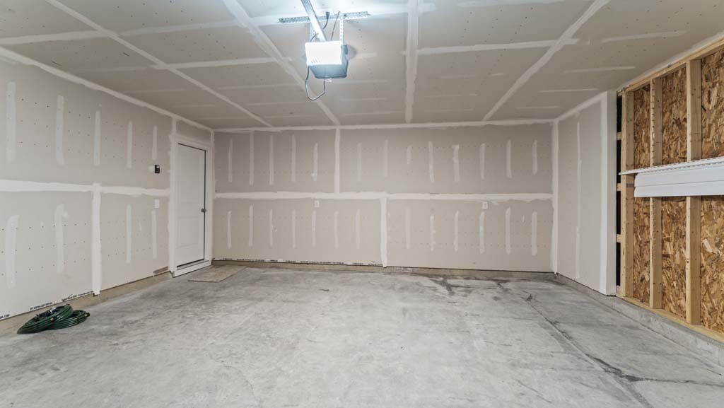 Two car garage with concrete flooring.