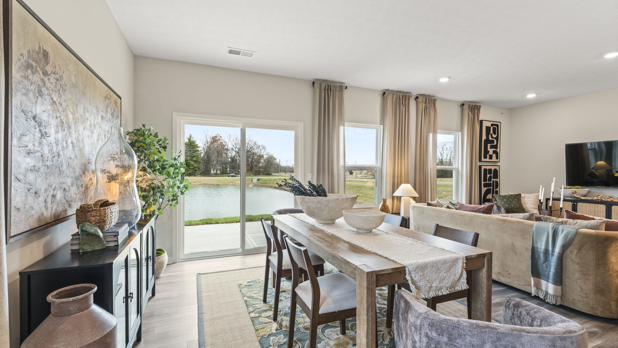 Dining area with modern art decoration including glass jars, pottery, and contemporary art piece.