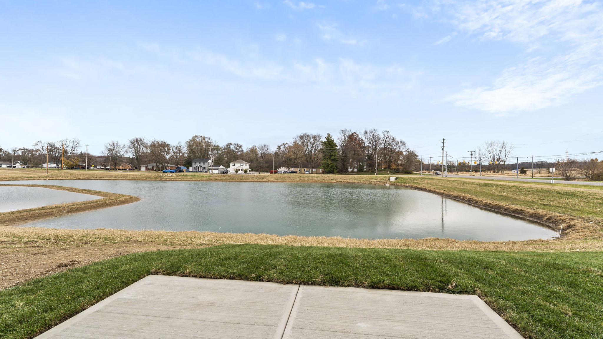 Backyard of the model with patio and view blue pond.