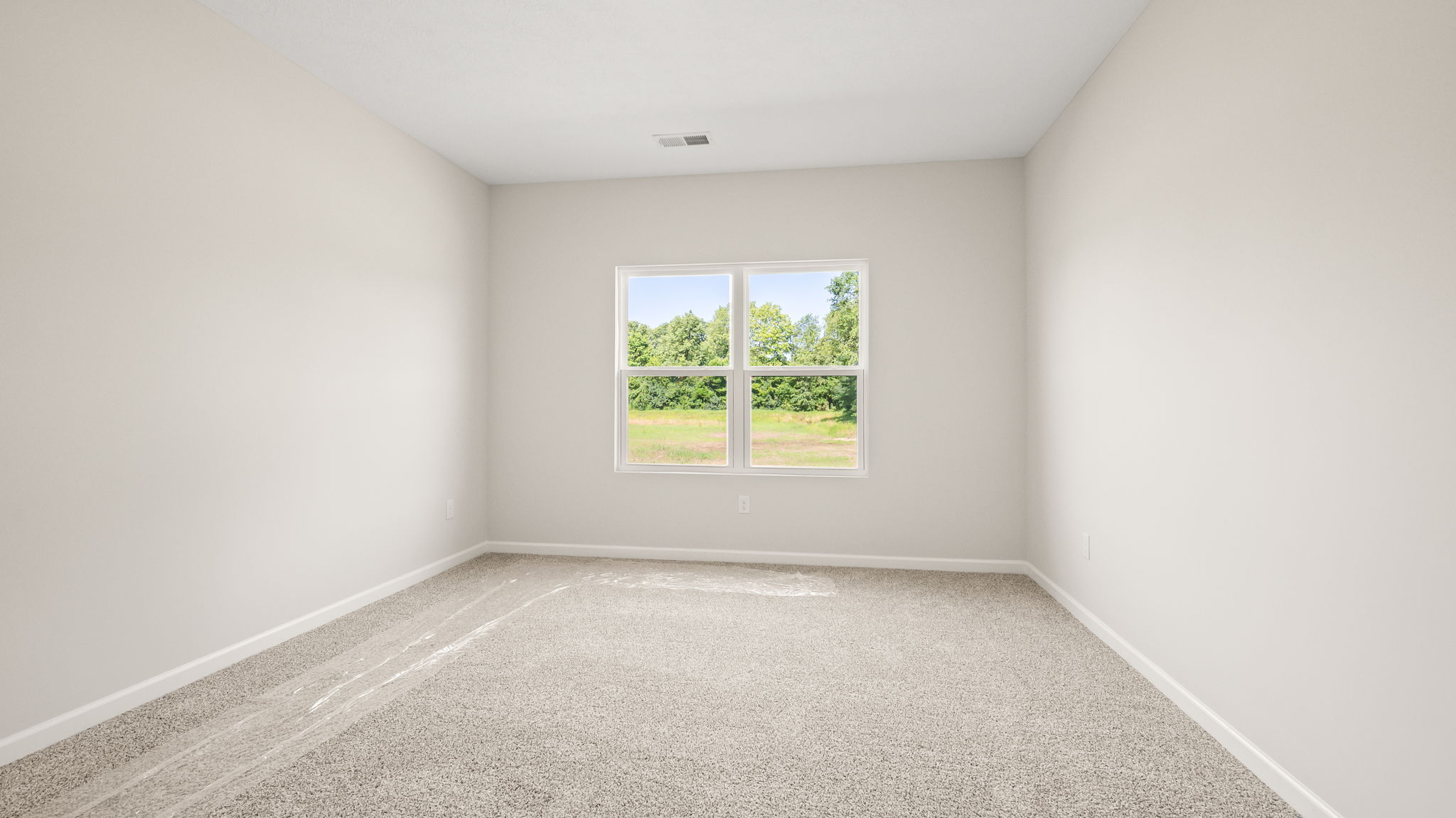 Carpeted primary bedroom with window